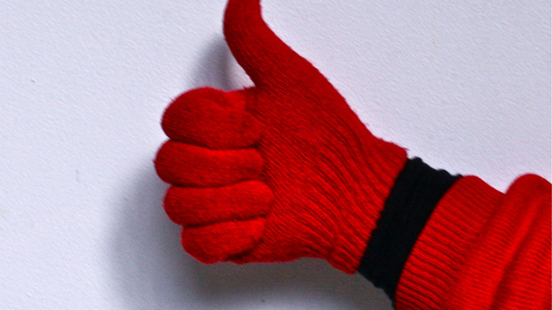 En hand med röd vante som gör tummen upp