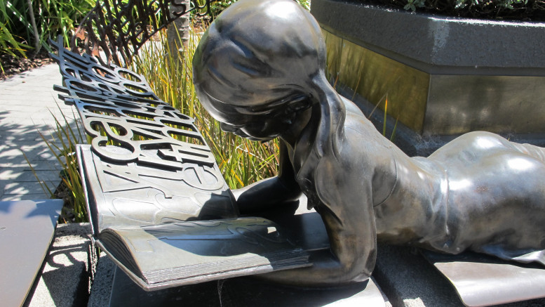 Staty av läsande flicka